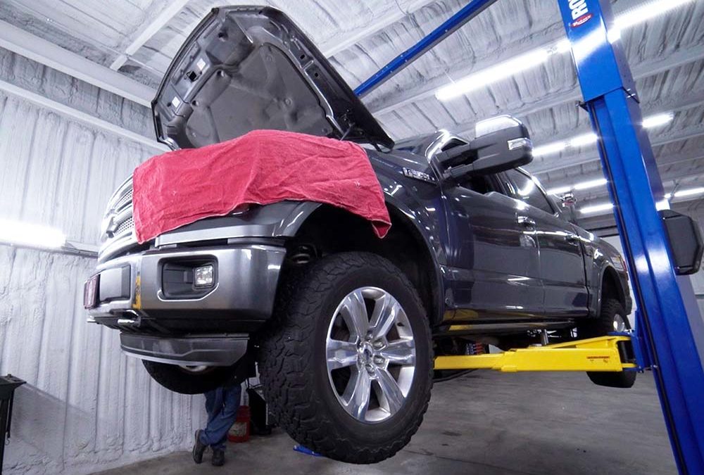 A pickup truck raised on a lift for auto repair at Ranchwood Autoworks in Yukon, OK.
